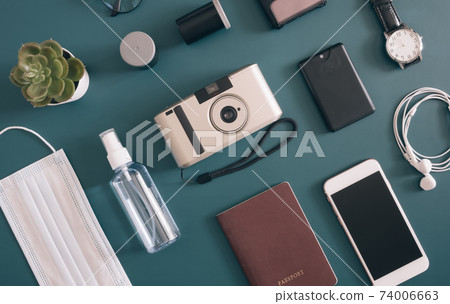 top view travel concept with camera, map, passport and disposable face mask 74006663
