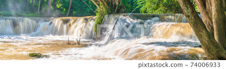 Water falls in tropical rainforest with rock and tree 74006933