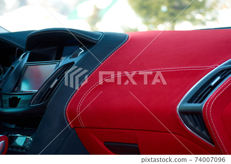 Car dashboard. Car interior details. Red and black alcantara with stitching Car dashboard. Car interior details. Red and black alcantara with stitching 74007096