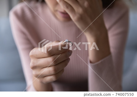 Frustrated millennial unhappy woman denied marriage, holding ring in hand. 74007550