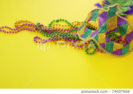 Mardi gras or carnival mask with beads on yellow background. Venetian mask. Mardi gras or carnival mask with beads on yellow background. Venetian mask. 74007666