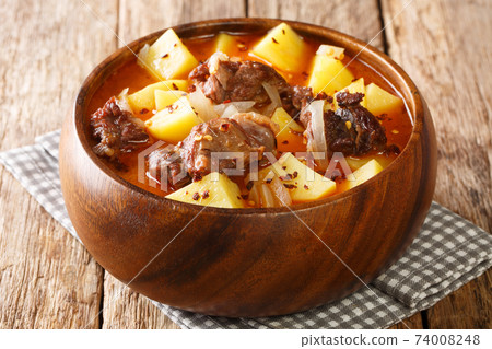 Spicy lamb stew and potatoes in pepper sauce close-up in a bowl. horizontal 74008248