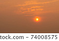 Beautiful big orange sun at sunset sky. Orange sky cloud and sun. 74008575
