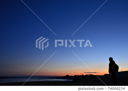 People looking at the dusk sky and the sea People looking at the dusk sky and the sea 74009234