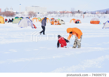 父母和孩子在冶煉釣魚場玩耍 74009772