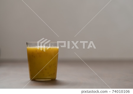 Mango lulo smoothie on walnut wood table with copy space Mango lulo smoothie on walnut wood table with copy space 74010106