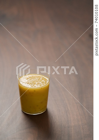 Mango lulo smoothie on walnut wood table with copy space Mango lulo smoothie on walnut wood table with copy space 74010108