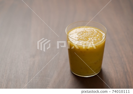 Mango lulo smoothie on walnut wood table with copy space Mango lulo smoothie on walnut wood table with copy space 74010111