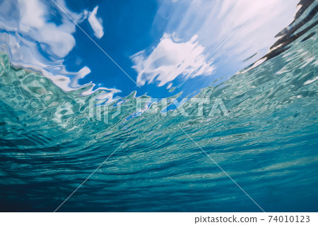 Surface of blue ocean with sky and sunlight underwater in Hawaii Surface of blue ocean with sky and sunlight underwater in Hawaii 74010123