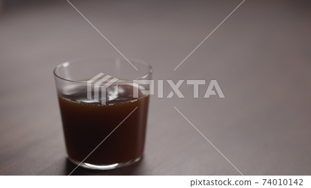 coffee pour into tumbler glass on walnut table coffee pour into tumbler glass on walnut table 74010142