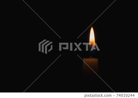 burning candle on black background burning candle on black background 74010244