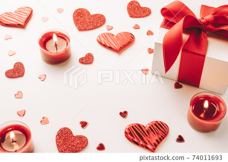 Happy days background. Red love hearts, romantic gift box, Valentines day candle on white table. Romantic message template with copy space. 74011693