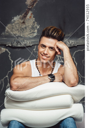 Man with a white pillow on a gray background. Concept of comfortable sleep. orthopedic pillow Man with a white pillow on a gray background. Concept of comfortable sleep. orthopedic pillow 74012935