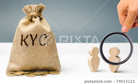 Money bag with the word KYC and two people. Know Your Customer Client concept. Verify the identity, suitability and risks involved with maintaining a business relationship. Anti-bribery compliance. 74013123