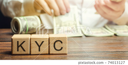 Wooden blocks with the word KYC - Know Your Customer / Client. Verify the identity, suitability and risks involved with maintaining a business relationship. Anti-bribery compliant 74013127