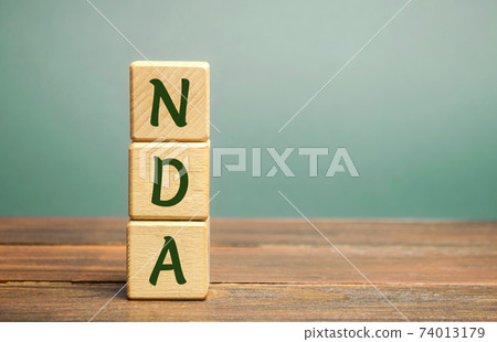 Wooden blocks with the word NDA - Non disclosure agreement. A legal contract entered into by two parties with limited access to third parties. Business concept Wooden blocks with the word NDA - Non disclosure agreement. A legal contract entered into by two parties with limited access to third parties. Business concept 74013179
