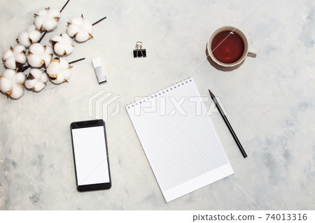 Flat lay composition with cotton branch and mobile telephone, cup of tea, gray background. Delicate white cotton flowers 74013316