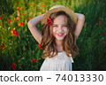 cute little girl in meadow with red poppies 74013330