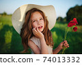 cute little girl in meadow with red poppies 74013332