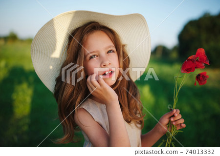 cute little girl in meadow with red poppies 74013332