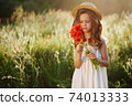 cute little girl in meadow with red poppies 74013333