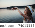 little cute girl with long hair on the lake 74013335