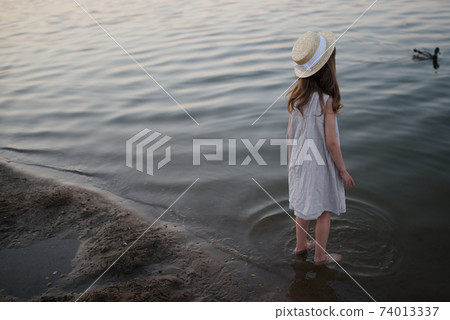 little cute girl with long hair on the lake little cute girl with long hair on the lake 74013337