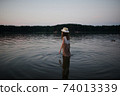 little cute girl with long hair on the lake 74013339