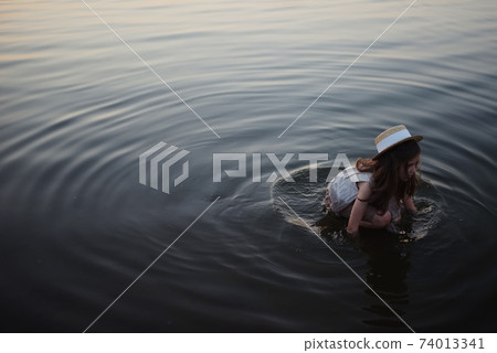 little cute girl with long hair on the lake 74013341