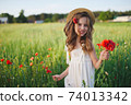 cute little girl in meadow with red poppies 74013342