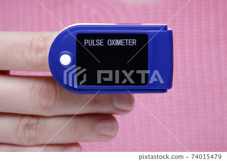 pulse oximeter on the hand of a girl in a pink sweater 74015479
