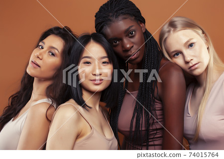 young pretty asian, caucasian, afro woman posing cheerful together on brown background, lifestyle diverse nationality people concept 74015764
