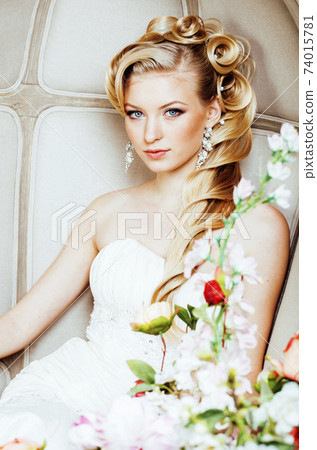 beauty emotional blond bride in luxury interior dreaming, crazy complicate hairstyle, many flowers 74015781