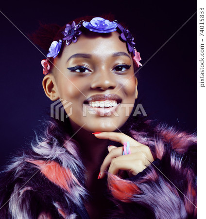 young pretty african american woman in spotted fur coat and flowers on head smiling on black background, fashion people concept young pretty african american woman in spotted fur coat and flowers on head smiling on black background, fashion people concept 74015833