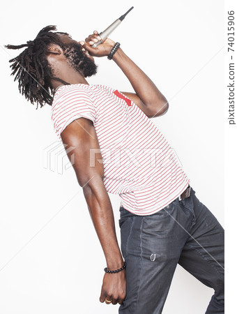 young handsome african american boy singing emotional with microphone isolated on white background, in motion gesturing smiling, lifestyle people concept close up 74015906