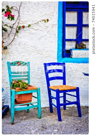 Typical cute wooden chairs in street taverna in Greece. artistic picture 74015941