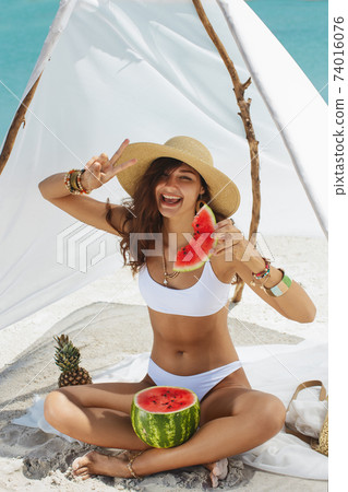 Woman on the Tropical Beach Eating Watermelon Woman on the Tropical Beach Eating Watermelon 74016076