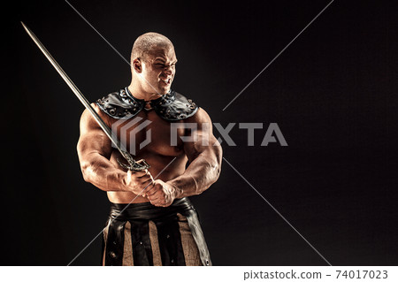 Severe barbarian in leather costume with sword Severe barbarian in leather costume with sword 74017023