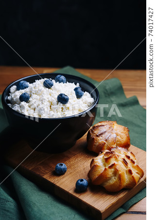 Cottage Cheese In Bowl. Homemade Curd Cheese Served With currant berries or blueberry. Healthy breakfast concept. Cottage Cheese In Bowl. Homemade Curd Cheese Served With currant berries or blueberry. Healthy breakfast concept. 74017427