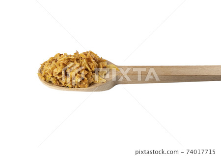 Crispy carmelized fried onion flakes in wooden spoon isolated on white background. Spices and food ingredients. Crispy carmelized fried onion flakes in wooden spoon isolated on white background. Spices and food ingredients. 74017715
