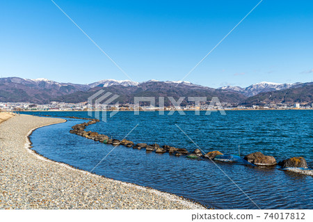 "Nagano Prefecture" A distant snowy mountain seen over Lake Suwa "Nagano Prefecture" A distant snowy mountain seen over Lake Suwa 74017812