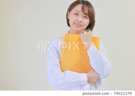 拿著橙色文件的一名微笑的護士 74022379