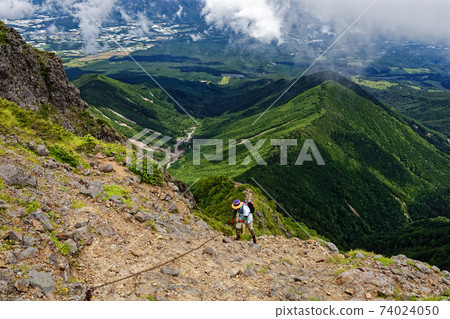 View of climbers climbing the chain of Yatsugatake mountain range and Shinkoji ridge and the direction of Mt. Ushikubi and Kiyosato View of climbers climbing the chain of Yatsugatake mountain range and Shinkoji ridge and the direction of Mt. Ushikubi and Kiyosato 74024050