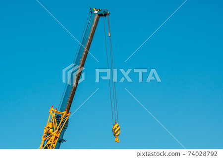 The hook of a crane without a load on the background of blue sky The hook of a crane without a load on the background of blue sky 74028792