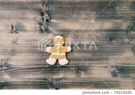Christmas cookies gingerbread man on a wooden texture. Christmas cookies gingerbread man on a wooden texture. 74028880