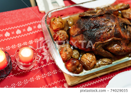 Duck baked until crispy with potatoes and apples on the Christmas table. Duck baked until crispy with potatoes and apples on the Christmas table. 74029035
