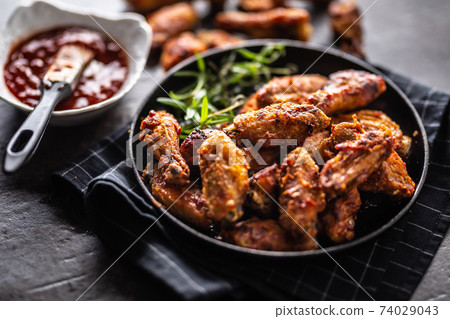 Chicken wings barbeque in a cast iron baking dish 74029043