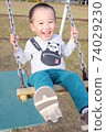 3-year-old boy playing on a swing 74029230