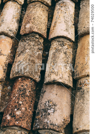 The texture of the old brown shingles on the roof of the building. 74029500