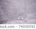 [冬季]暴風雪中行駛的汽車的大燈 74030592